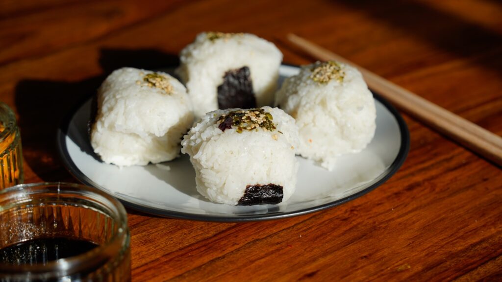 A white plate topped with desserts next to a glass of liquid